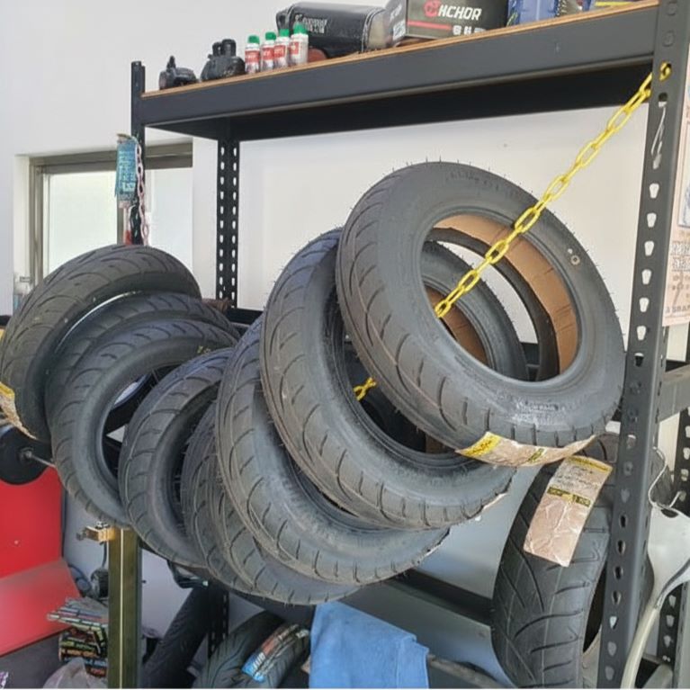 Yellow Plastic Chain used to secure and organize multiple motorcycle or scooter tires on a warehouse storage rack.